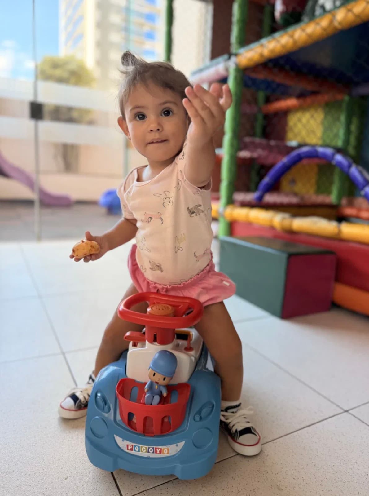 Lara no carrinho de brinquedo no playground